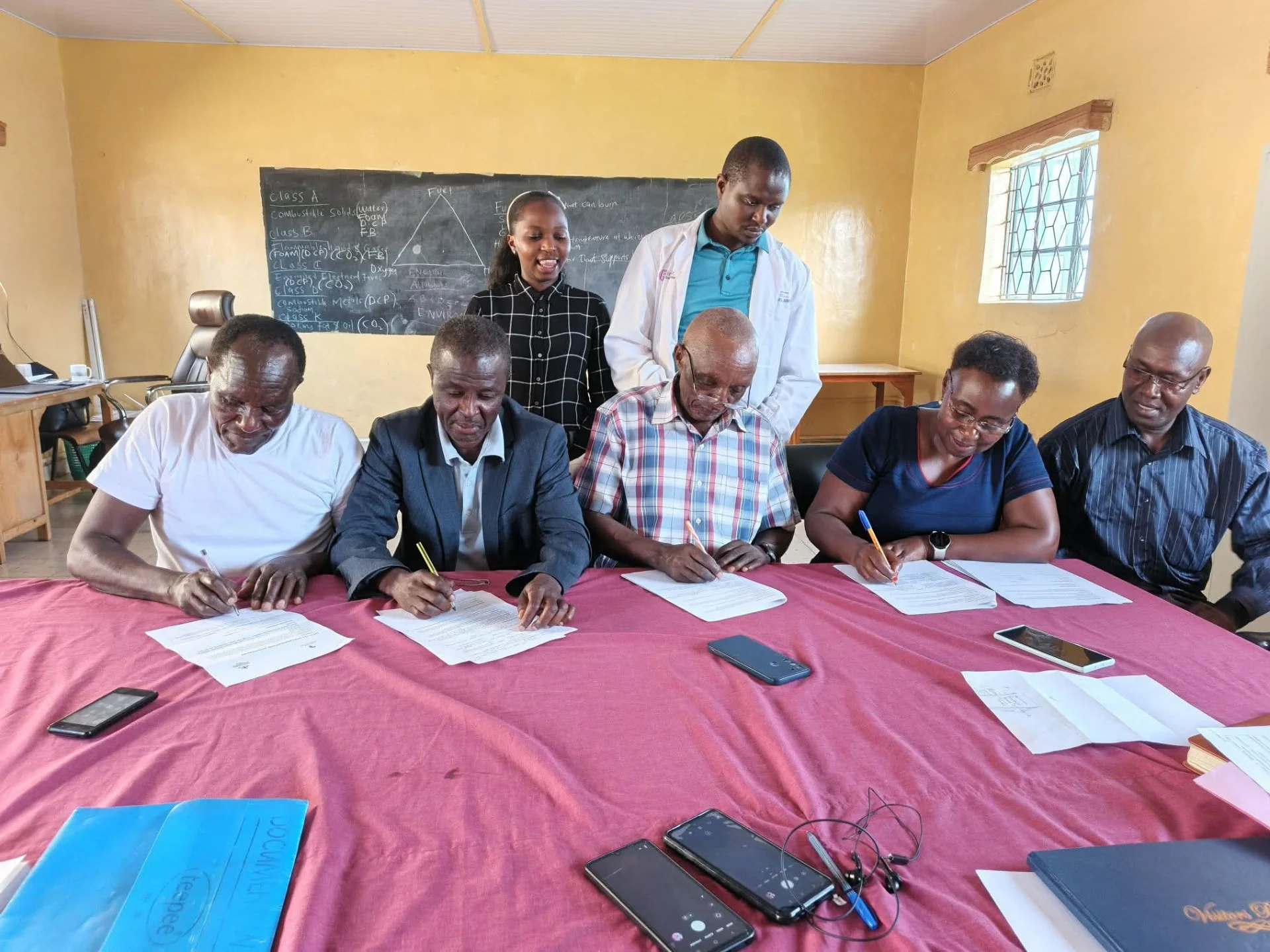 Representatives gather to sign documents during a partnership meeting.